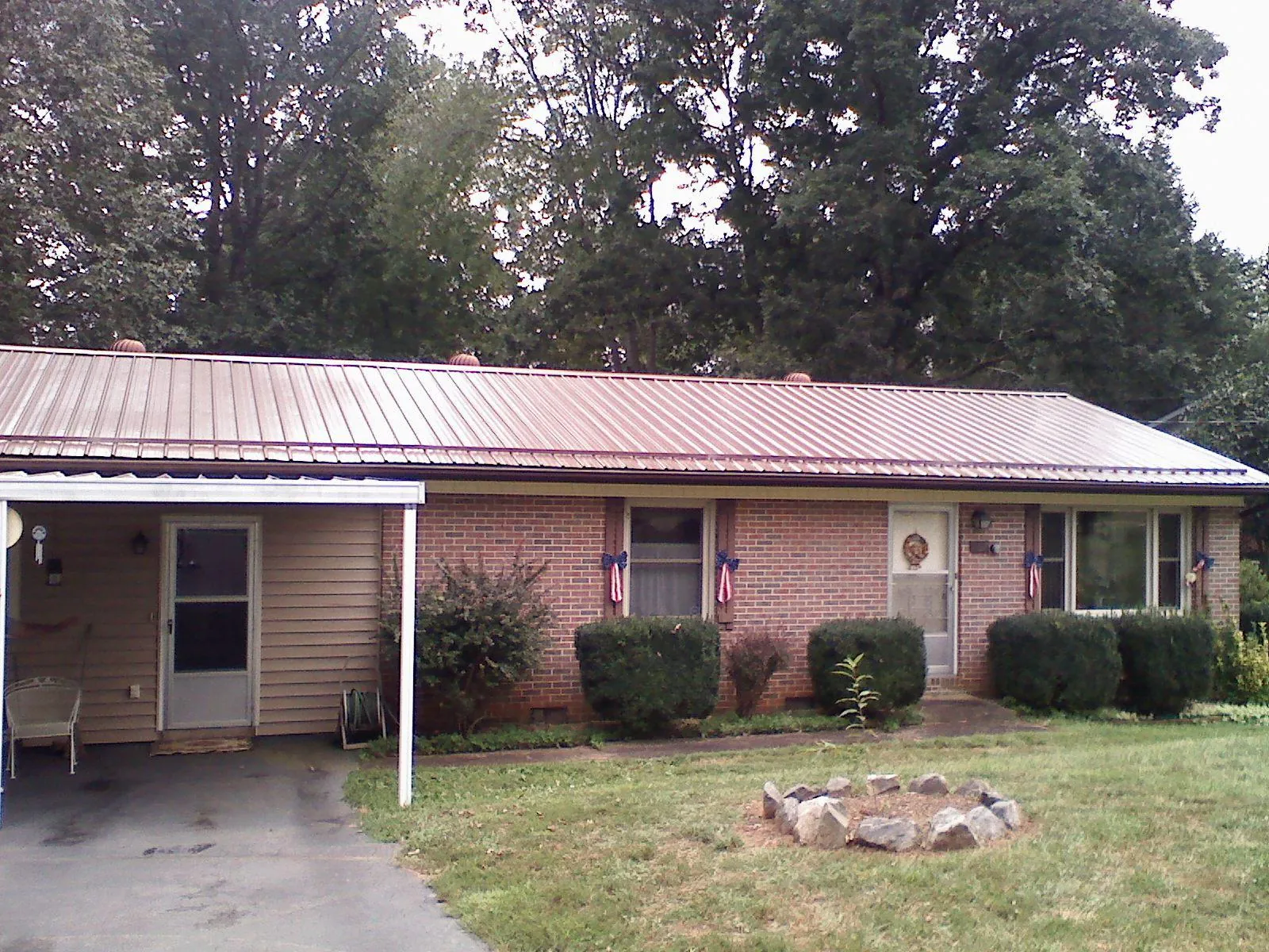 Bronze metal roof and carport on a brick ranch home — Roof Repair work by our crew in Virginia